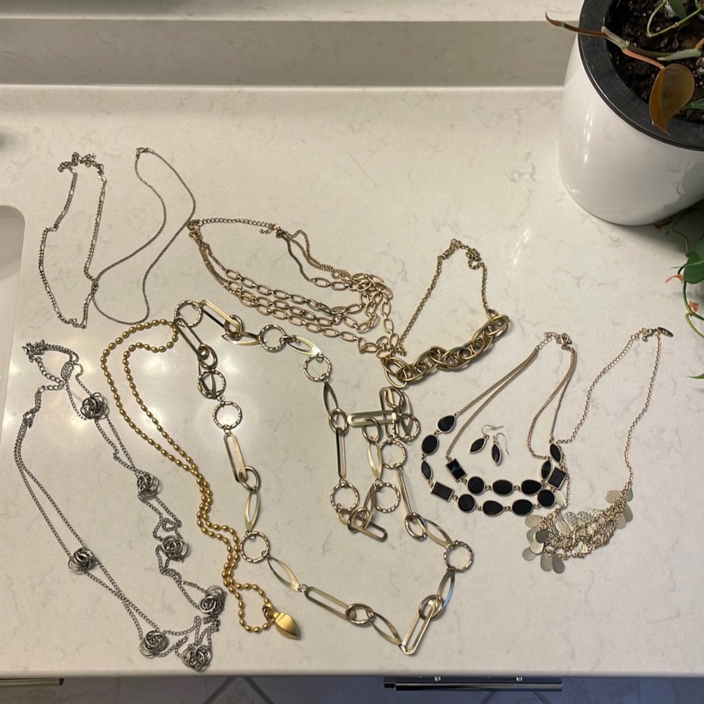 Assortment of gold & silver necklaces. One with a matching set of earrings.